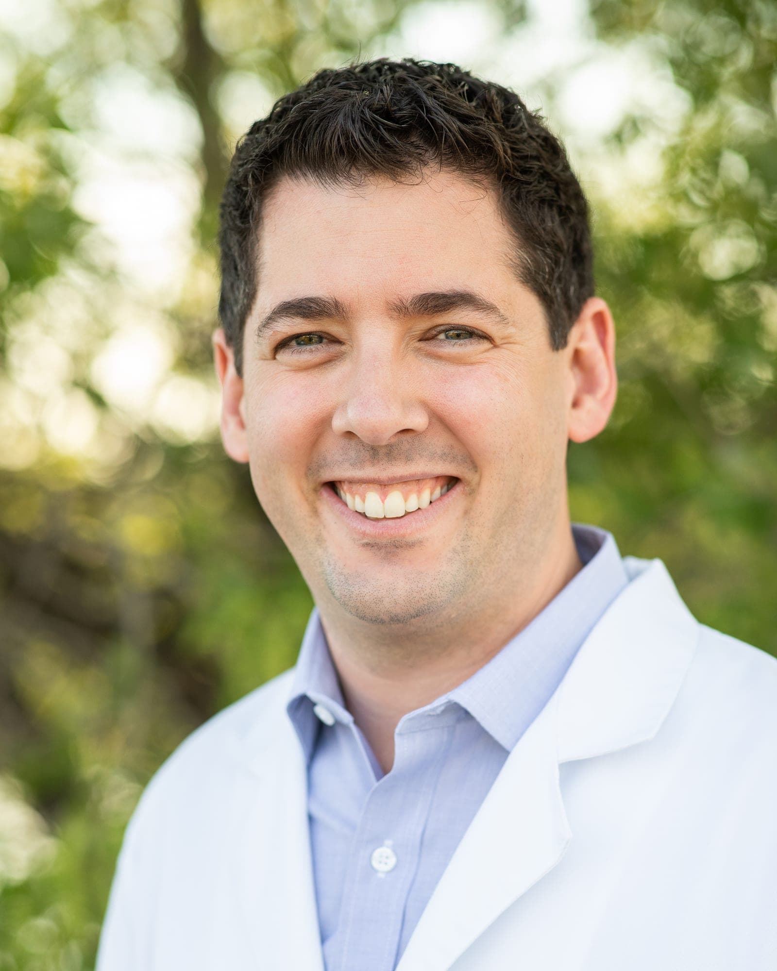Dr. Tom Gutberg smiling, in a white coat.